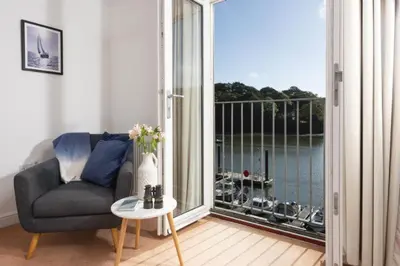 a living room with a chair and a large window at Waterfront House in Saint Clement