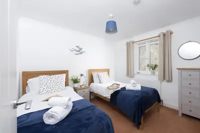 a bedroom with two beds and a window at Waterfront House in Saint Clement