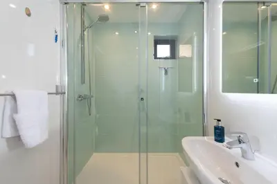 a bathroom with a glass shower and a sink at Wavelength in St. Agnes