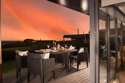 a dining room with a table and chairs on a patio at Wavelength in St. Agnes