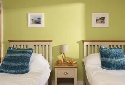 a bedroom with two beds with blue pillows at Triskel in St. Agnes
