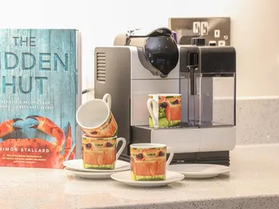 two coffee cups on a counter next to a coffee maker at Idlewild, 2 Wheal Turnavore in St. Agnes