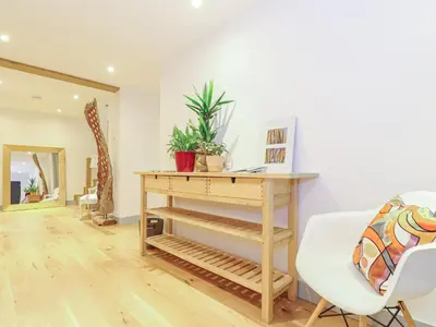 a living room with a wooden table and a white chair at Idlewild, 2 Wheal Turnavore in St. Agnes