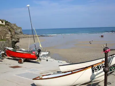 a boat on the beach with a beach in the background at Idlewild, 2 Wheal Turnavore in St. Agnes