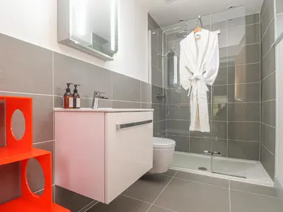 a bathroom with a shower and a toilet and a sink at Idlewild, 2 Wheal Turnavore in St. Agnes