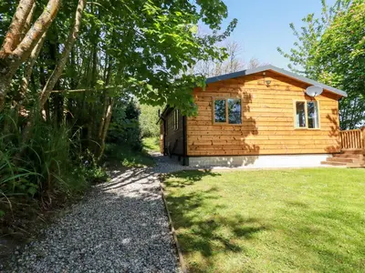 a small wooden house with a gravel path in front of it at Lodge Two in Truro