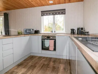 a kitchen with white cabinets and a counter top at Lodge Two in Truro