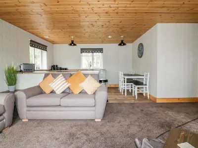 a living room with a couch and a kitchen at Lodge Two in Truro