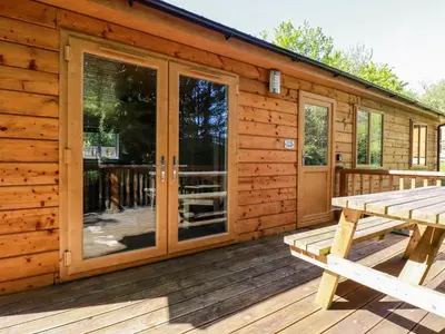 a cabin with a picnic table on the deck at Lodge Three in Truro
