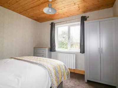 a bedroom with a bed and a window at Lodge Three in Truro