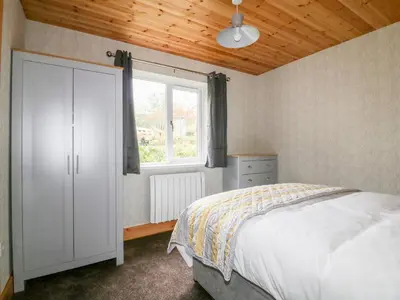 a bedroom with a white bed and a window at Lodge Three in Truro