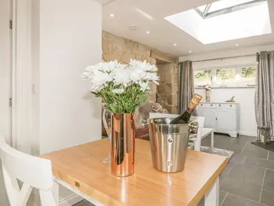a dining room with a table with a bottle of wine at The Bull Pen in St Austell