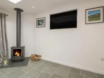 a living room with a fireplace and a flat screen tv at The Bull Pen in St Austell