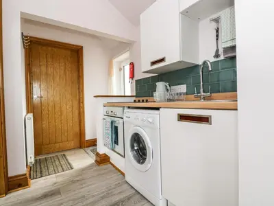 a kitchen with a washing machine and a sink at Glenhaven in Tintagel