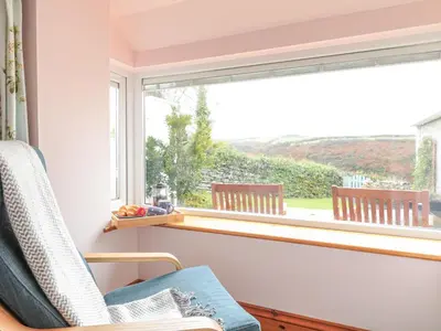 a window in a room with a chair in front of it at Glenhaven in Tintagel
