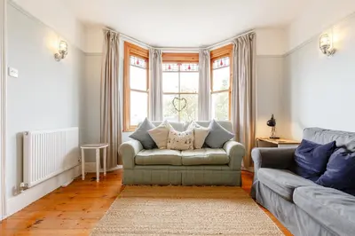 a living room with a couch and a window at Wisteria in St Austell