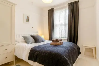 a bedroom with a bed with a teddy bear on it at Wisteria in St Austell