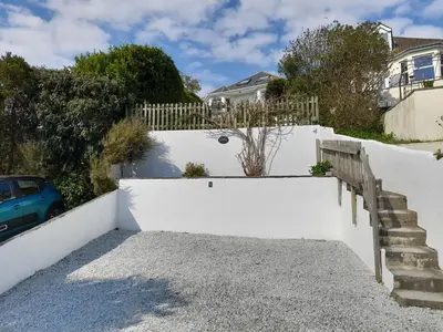 a white fence and stairs in front of a house at Wisteria in St Austell