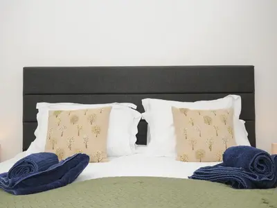a bed with two blue towels on top of it at Elmbank in Looe