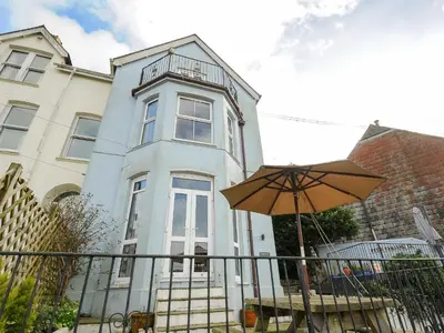 a house with an umbrella in front of it at Elmbank in Looe