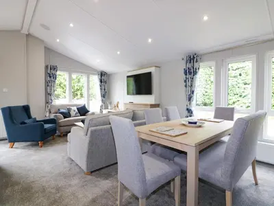 a living room with a table and chairs and a couch at Pinehurst Lodge in Redruth