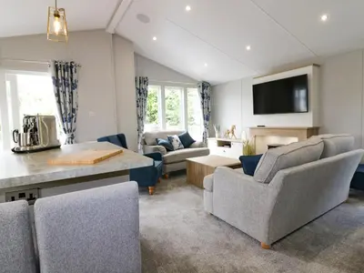 a living room with a couch and a table and chairs at Pinehurst Lodge in Redruth