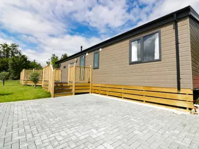 a house with a wooden fence and a patio at Pinehurst Lodge in Redruth