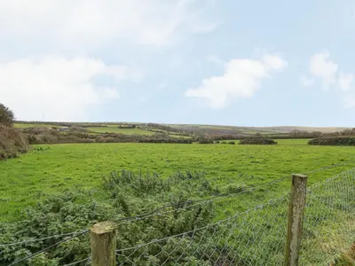 a field of green grass with a fence at Underlanes in Camelford