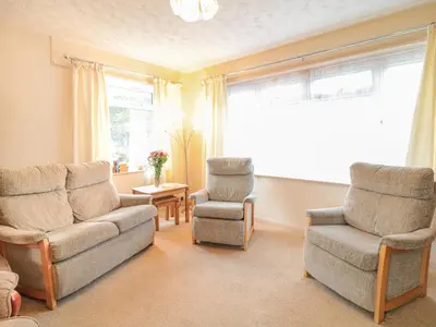 a living room with a couch and two chairs and a window at Underlanes in Camelford