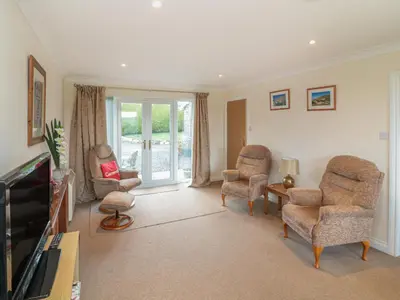 a living room with two chairs and a television at Little Lanes in Camelford