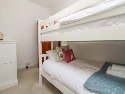 a bedroom with a bunk bed with a white bunk bed at Riversdale Cottage in Wadebridge
