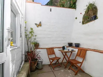 a small patio with two chairs and a table at Polkirt Forge in Mevagissey