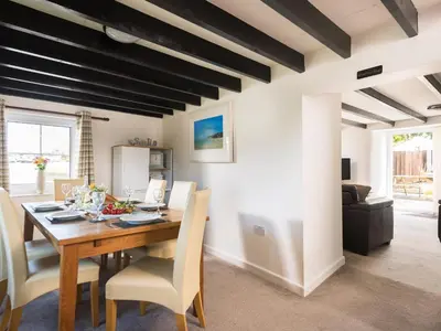 a dining room with a wooden table and chairs at Karrek in Tintagel