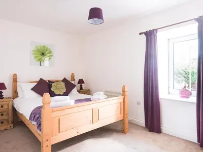 a bedroom with a wooden bed and a window at Karrek in Tintagel