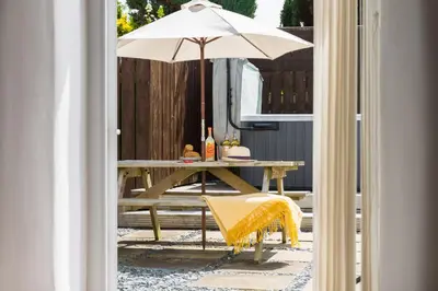 a table with an umbrella on a patio at Karrek in Tintagel