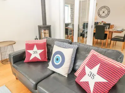 a black leather couch with pillows on it in a living room at Atlantic Reach in Bude