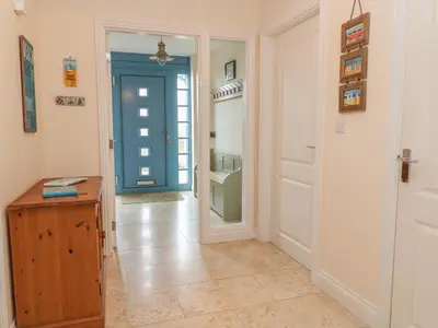 a hallway with a blue door and aoyer with a floor at Atlantic Reach in Bude