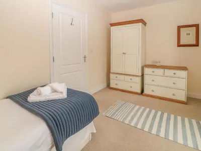 a bedroom with a bed and a dresser at Atlantic Reach in Bude