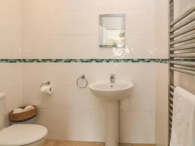 a white bathroom with a toilet and a sink at Atlantic Reach in Bude