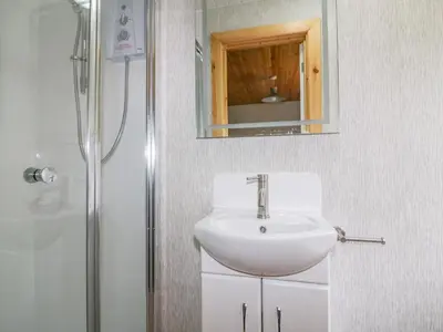 a bathroom with a sink and a mirror and a shower at Lodge One in Truro