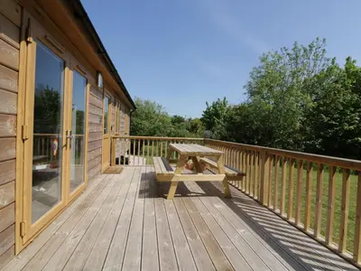a picnic table on the deck of a cabin at Lodge One in Truro