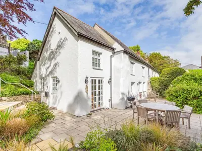 an exterior view of a white cottage with a table and chairs at 3 Rose Cottages in St. Agnes