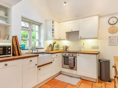 a kitchen with white cabinets and a sink at 3 Rose Cottages in St. Agnes