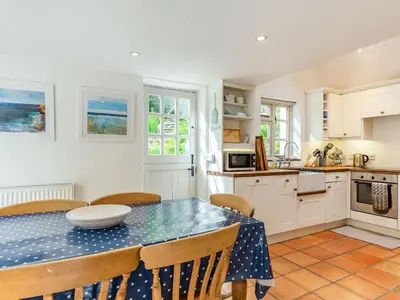 a kitchen and dining room with a table and chairs at 3 Rose Cottages in St. Agnes