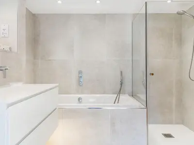 a bathroom with a tub and a glass shower at 3 Rose Cottages in St. Agnes