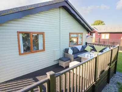 a deck with a couch and a table at Smugglers Shack in Polperro