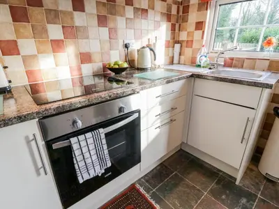 a kitchen with a stove and a sink at 1 Rose Cottages in Looe