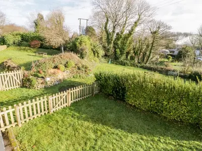 a garden with a wooden fence in a yard at 1 Rose Cottages in Looe