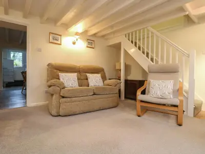 a living room with a couch and a chair at 3 Rose Cottages in Looe