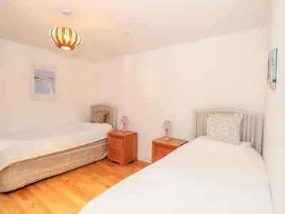a bedroom with two beds and two night stands at Ocean Blue in Penzance